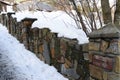 Stone fence along the road covered with snow Royalty Free Stock Photo