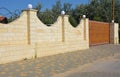 Stone fence with gate and entrance door. House fencing. Royalty Free Stock Photo