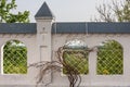 Stone fence of an Orthodox monastery with lattice windows and a vine