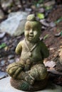 Stone figurine on the ground among the leaves