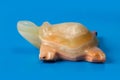 A stone figurine of a turtle on a blue background. Royalty Free Stock Photo