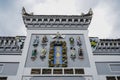 Stone figurines on ancient tile-roofed building in cloudy sky