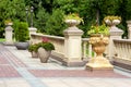 Stone flowerpots at the railing with balustrades on the backyard.