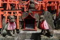 Stone fox statues and many small torii.