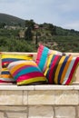 Stone garden bench with colorful pillows