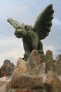 A stone gargoyle on a stone fence stands watch.