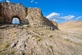 Stone Gate of the fortress with crumbling walls and huge bricks of the old grungy town in the desert valley