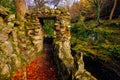 Stone gate of old pathway with river below and green mossy rocks in Tollymore Forest Park Royalty Free Stock Photo