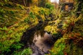 Stone gate of old pathway with river below and green mossy rocks in Tollymore Forest Park Royalty Free Stock Photo