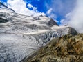 The Stone Glacier in the Swiss Alps, its crevasses with snowy slopes, and blue sky in the background