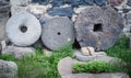 Stone granite wheels with rusted metal rim isolated on green grass near wall Royalty Free Stock Photo