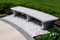 Stone gray bench strewn with white stone pebbles in a garden. Royalty Free Stock Photo