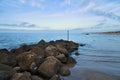 Stone groyne juts out into the water off the coast in Denmark. Sunny day. Landscape