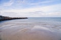 Stone groyne juts out into the water off the coast in Denmark. Sunny day. Landscape Royalty Free Stock Photo