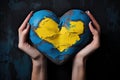 Stone heart in colors of Ukrainian flag in hands of woman. Generative AI