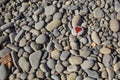 stone heart painted with a red paint marker on the pebble as a gift for Saint Valentine day on the pebble background Royalty Free Stock Photo