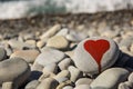 stone heart painted with a red paint marker on the pebble as a gift for Saint Valentine day on the pebble background Royalty Free Stock Photo