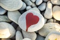 stone heart painted with a red paint marker on the pebble as a gift for Saint Valentine day on the pebble background Royalty Free Stock Photo