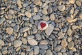 stone heart painted with a red paint marker on the pebble as a gift for Saint Valentine day on the pebble background Royalty Free Stock Photo