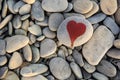 stone heart painted with a red paint marker on the pebble as a gift for Saint Valentine day on the pebble background Royalty Free Stock Photo