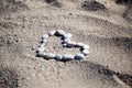 Stone heart shape on summer beach sand Royalty Free Stock Photo