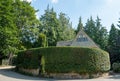 Stone house surrounded by a tall neat hedge in the unspoilt picturesque Cotswold village of Stanton in Gloucestershire UK. Royalty Free Stock Photo