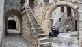 Stone houses in narrow street of old town, beautiful architecture with archs and stairs, Trogir, Dalmatia, Croatia