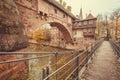 Stone houses and suspension bridge across the river in the historic city of Nuremberg with historical walls. Royalty Free Stock Photo