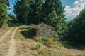 Stone hut on the bifurcation of a dirt road in a grove