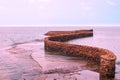 The stone installation in the form of a winding line goes into the sea lilac tint. Calm seascape. Rest in Asia