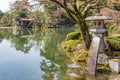 Stone Kotoji-toro lantern, teahouses, and trees reflected in Kasumi pond water, Kenrokuen gardens. Kanazawa, Japan Royalty Free Stock Photo