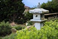 Stone lantern between evergreen plants, garden landscape design Royalty Free Stock Photo