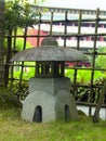 Stone lanterns in a Japanese garden with a bamboo fence in the background Royalty Free Stock Photo