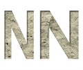 Stone letter N cut out of white paper on the background of the texture of natural stone close-up, decorative font