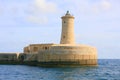 Stone lighthouse on end of breakwater Royalty Free Stock Photo