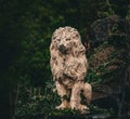 Stone lion statue covered with ivy in a garden setting Royalty Free Stock Photo