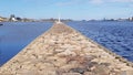 Stone long pier protecting berths for yachts on the Daugava River in the capital of Latvia Riga in April 2020