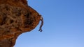 Stone man hanging from the rock above a shallow cave. The lone men are a mystery found in the northern Kaokoveld of Namibia,