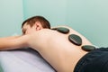 Stone massage man getting stone therapy massage at cabinet Royalty Free Stock Photo