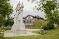 Stone memorial gateway before tile-roofed buildings in cloudy af