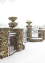 Stone & Metal Bared Fence in the Winter Snow