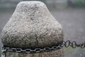 Stone milestone on a city street, part of prop chain fence