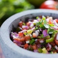 Stone molcajete with mexican pico de gallo salsa Royalty Free Stock Photo