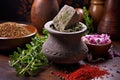 a stone mortar with crushed spices, fresh herbs in the background Royalty Free Stock Photo