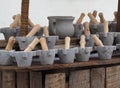 Stone mortar with wooden pestle in a shelf of a market. A stone pitcher in the middle Royalty Free Stock Photo