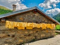 Stone mountain refuge with yellow clothes hanging outside to dry Alps, Trentino, Italy, Europe