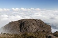 Stone mountain rock face above a sea of clouds Royalty Free Stock Photo