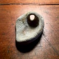 Stone with natural hole on antique wood table. Royalty Free Stock Photo