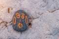 Grey Pebble with a orange painted smiling face. On a small stone is an image of a happy face. Concept: joy, happiness Royalty Free Stock Photo