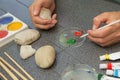 Stone painting. Dunking brush into the paint